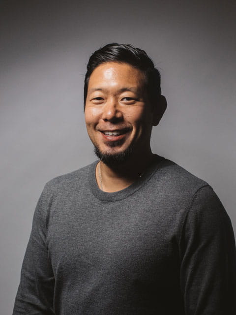 Portrait of Asian man Benny Yu in plain grey top smiling