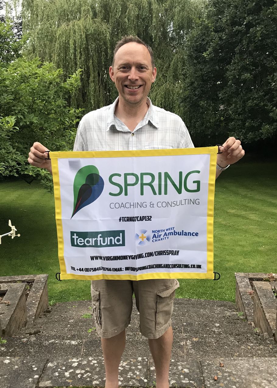 Chris Spray with banner promoting the charities he's fundraising for, including Tearfund.