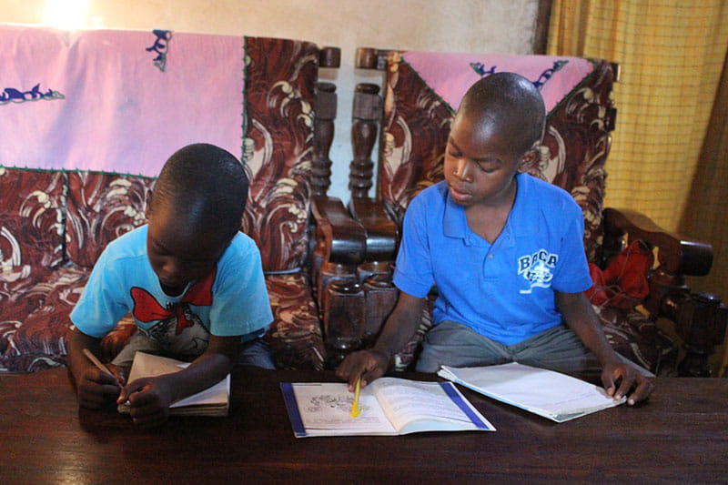 amos and John studying by solar powered light