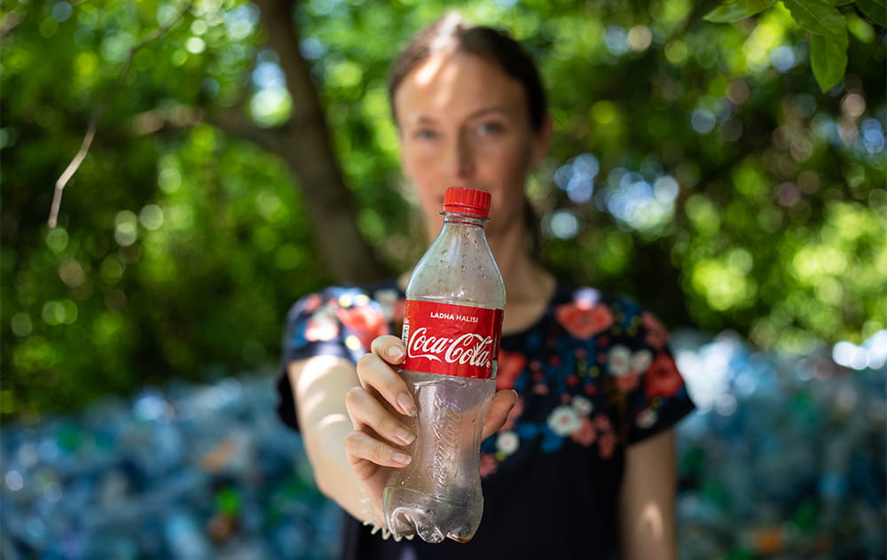 Clare Lyons holding a Coca-Cola bottle in Tanzania (Tearfund). 