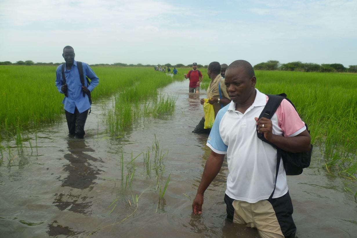 Tearfund staff wading to get to a feeding centre in South Sudan. Photo: George Kirimi/Tearfund