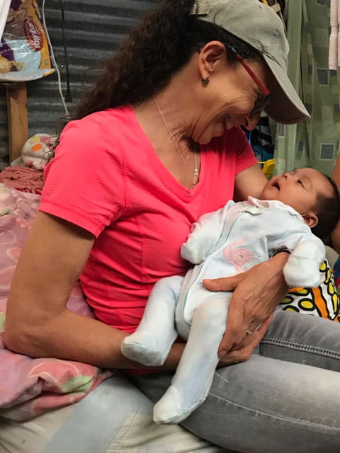 Tital holding baby in La Limonada slums