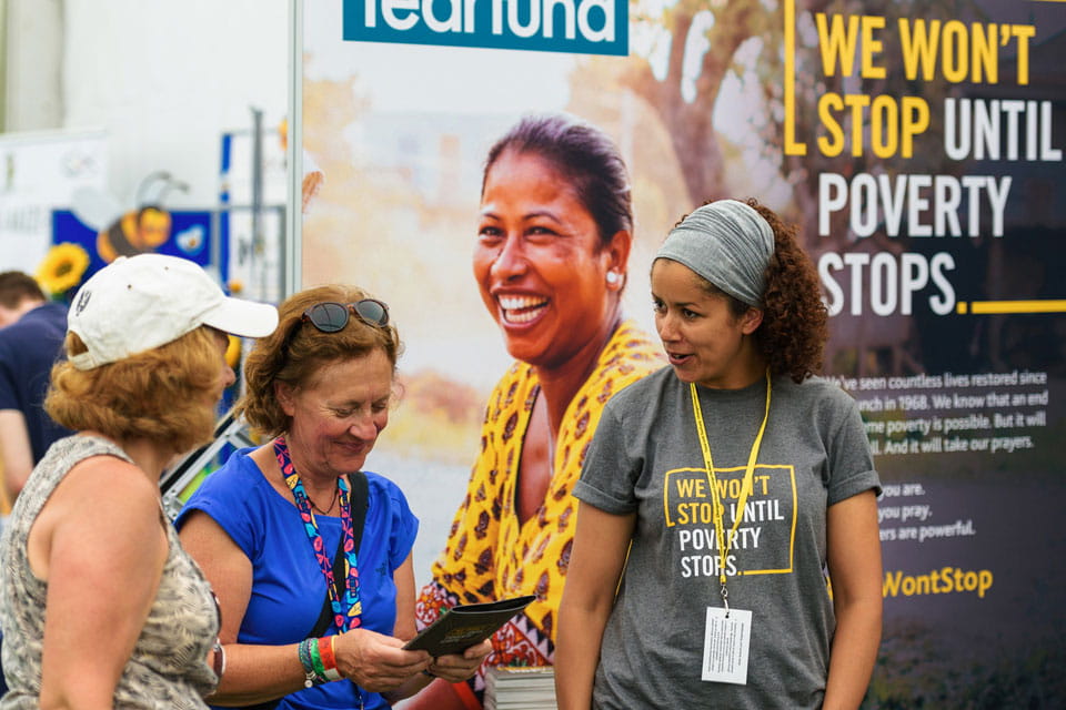 Supporters talk to Tearfund volunteer at exhibition stand