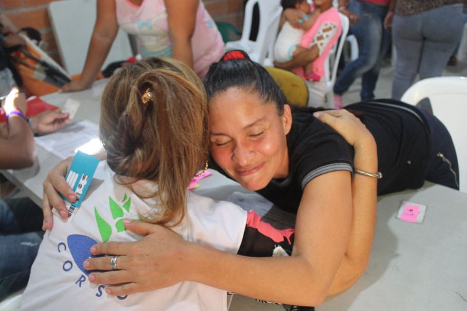 Migrant woman hugs church volunteer