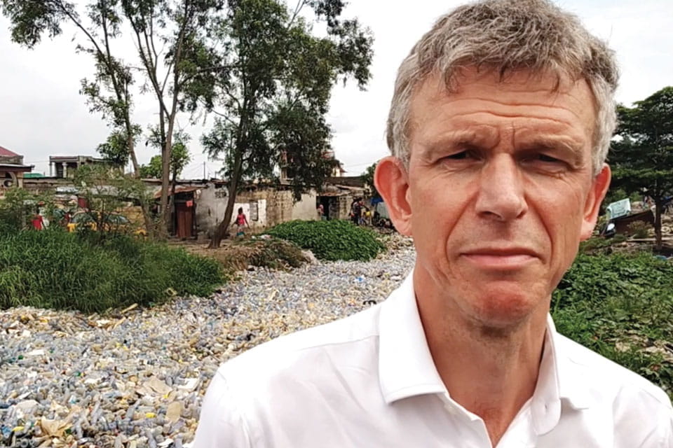 Nigel standing in front of the river of plastic