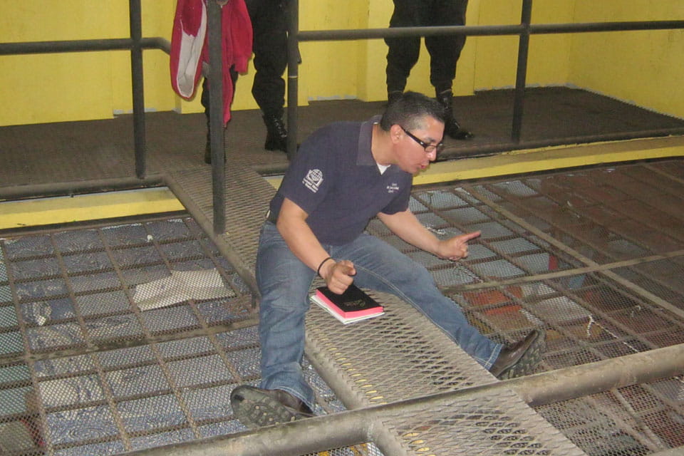 William Quiñones preaching on top of prison cages