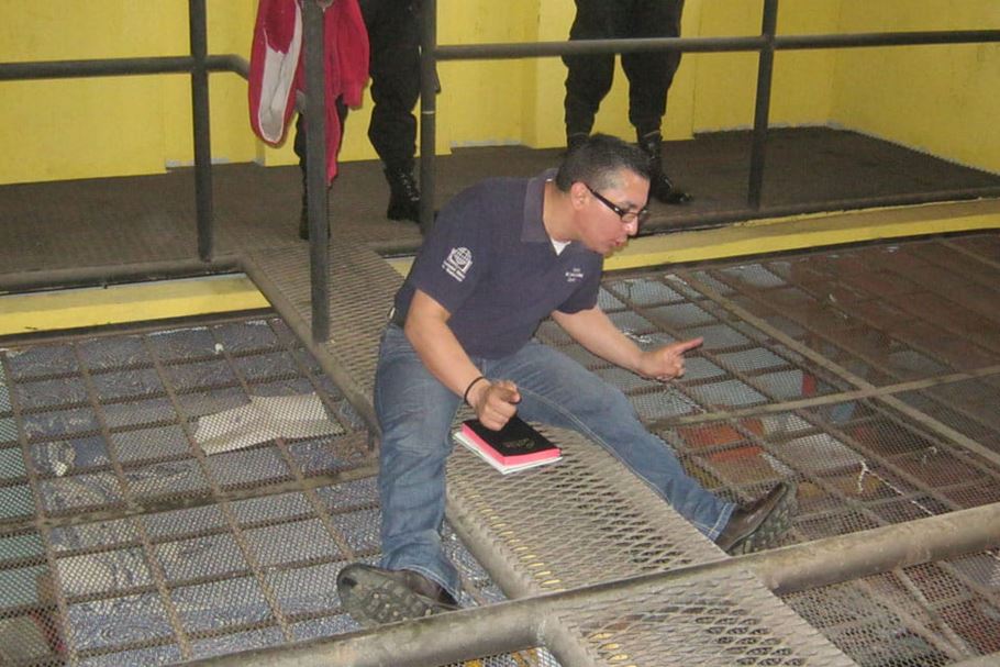William Quiñones preaching on top of prison cages
