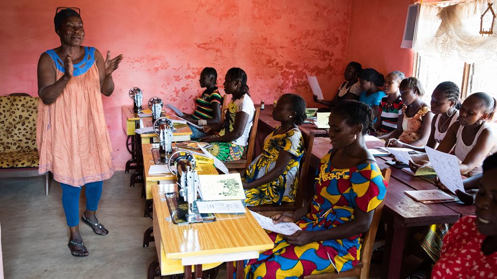 A woman stood in front of a class of students sat at desks