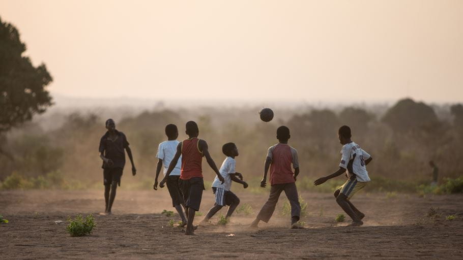 Children play a football game at sunset in a flood resettlement community. Credit: Ralph Hodgson/Tearfund