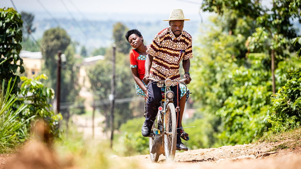 Jilbert gives a customer a lift on his bike taxi in Kigali. He was able to set up a bike taxi cooperative with support from a self-help group run by his local church. Credit: Marcus Perkins/Tearfund