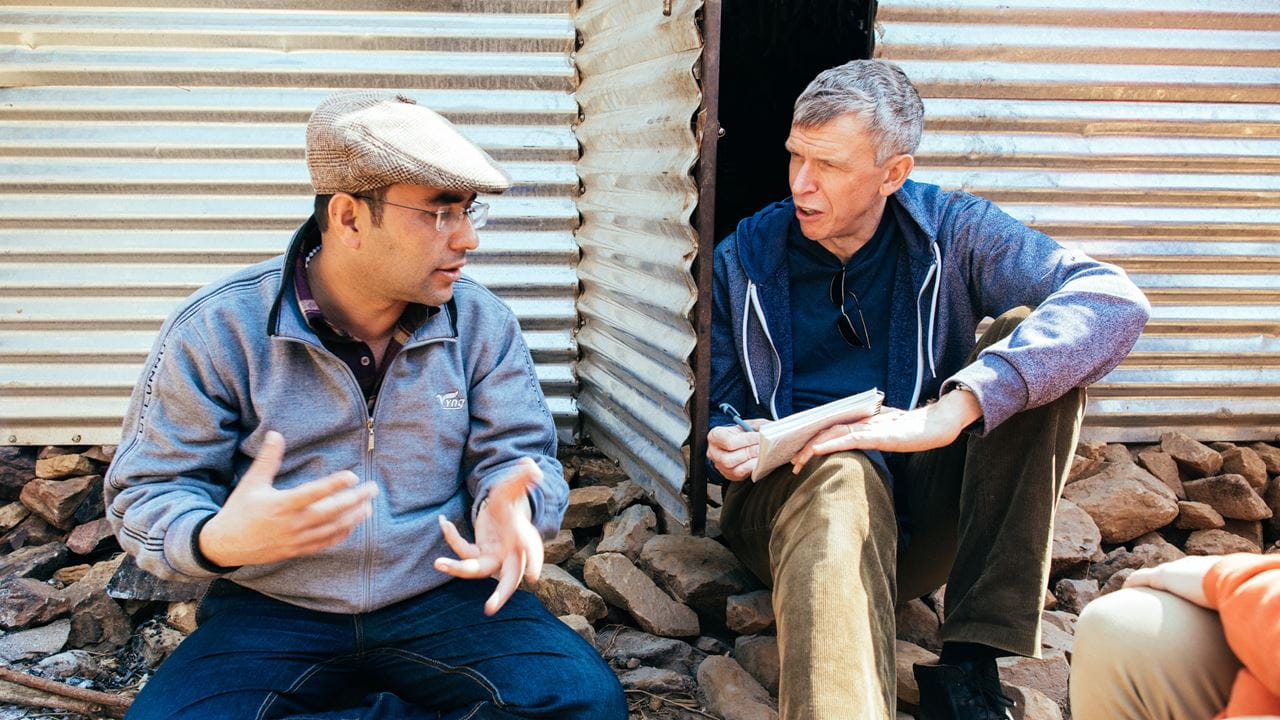 Tearfund's Nepal Response Manager, Rajan Ghimire, translates for Nigel Harris, Tearfund CEO, in Basanta village in Nepal. Photo credit: Tom Price/Tearfund