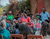 A woman talks to a group of people sat around her.
