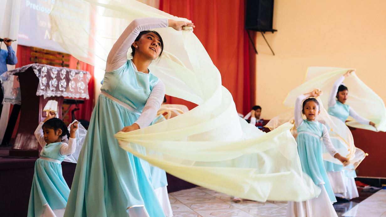 A woman and children dancing with fabric