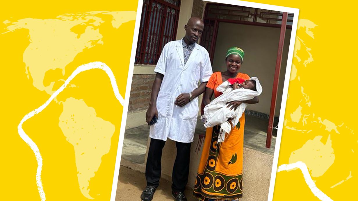 A nurse dressed in a white robe is stood with Cecile, smiling and holding her baby.
