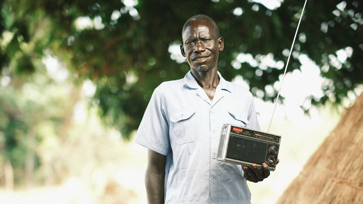 A man standing holding a radio
