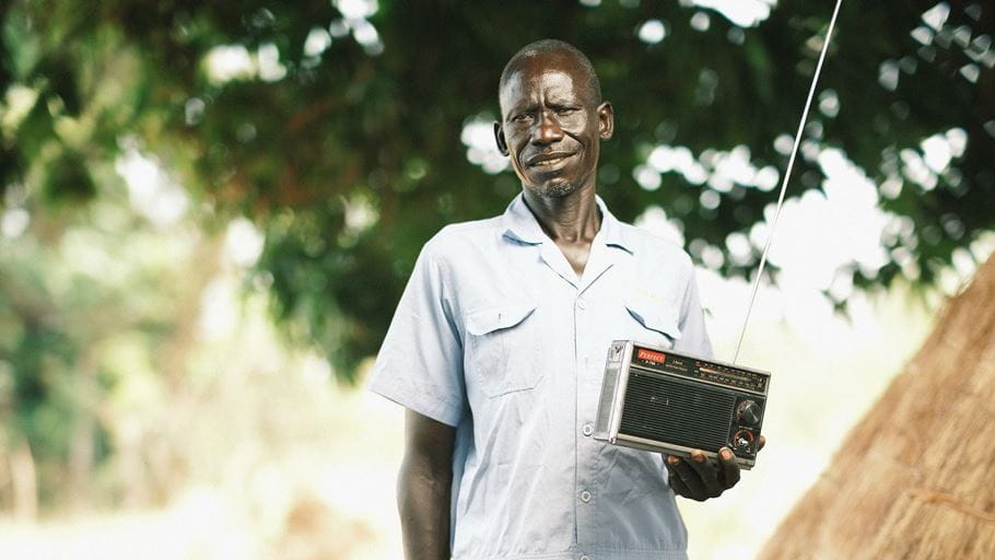 A man standing holding a radio