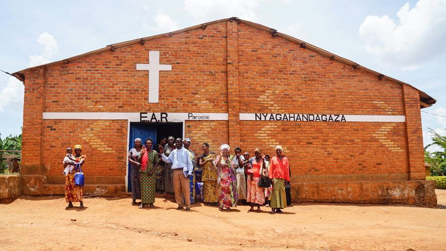 A group of people standing outside a brick church building