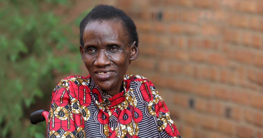 A woman sitting in front of a brick wall