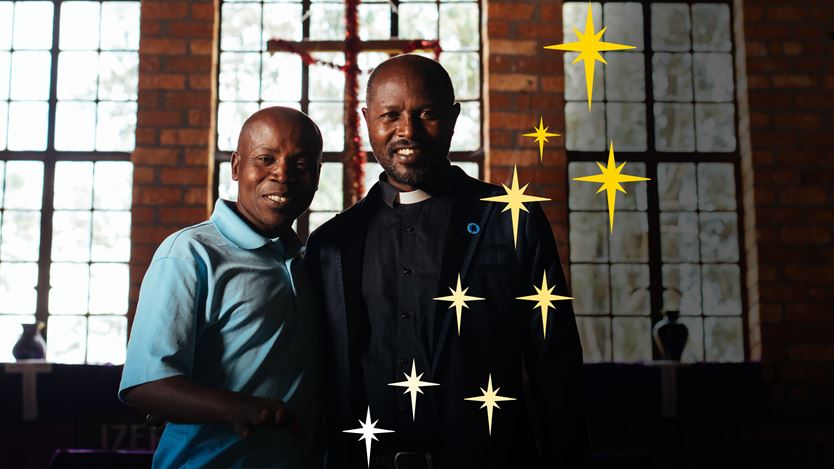 Two smiling men with windows and a crucifix in the background, and illustrated stars overlayed on the image