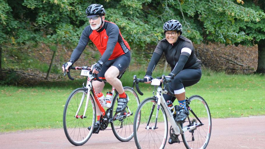 Two people cycling on a path in a park