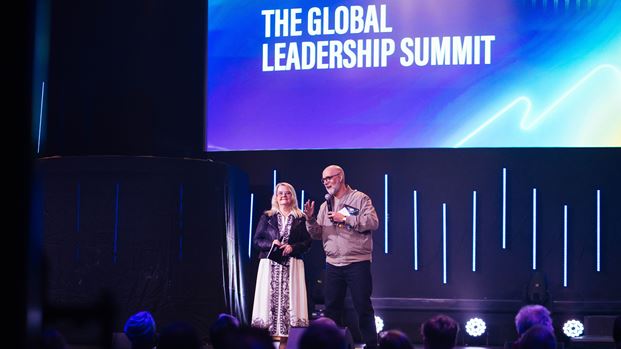 Speakers on stage at The Global Leadership Summit, screen reads "The Global Leadership Summit".