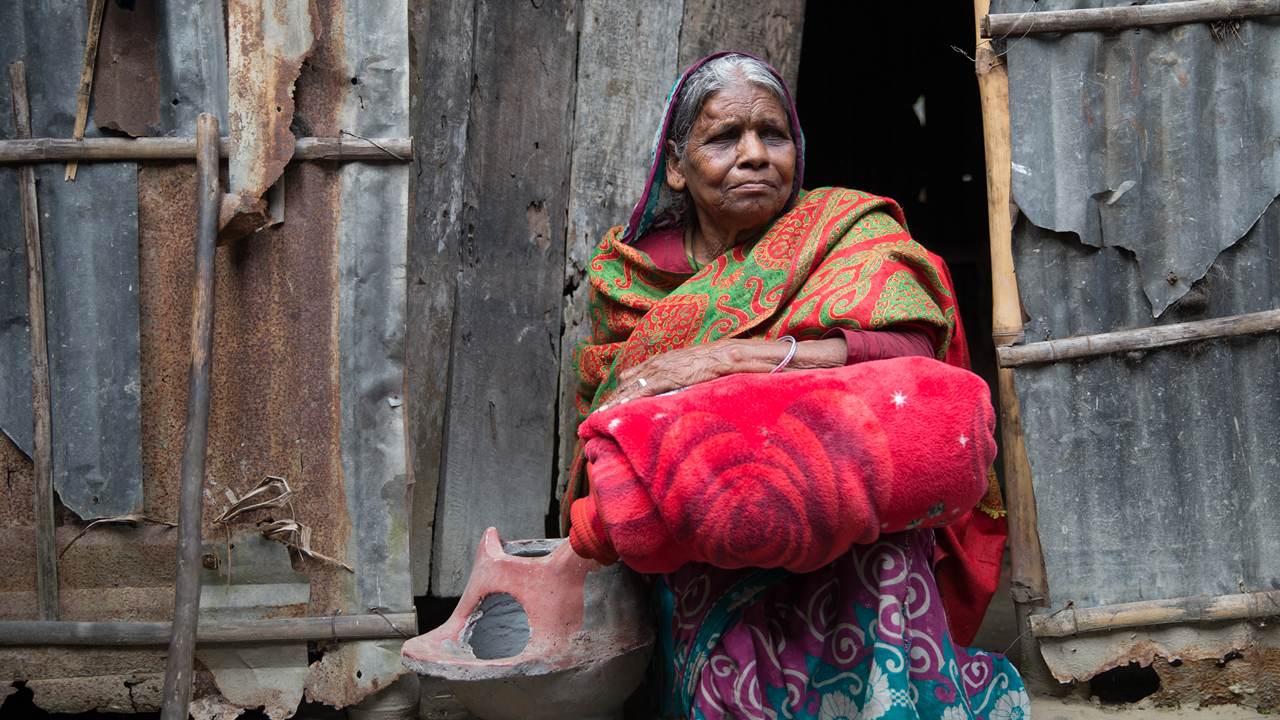 Mabia clutches a stove and blanket given to her after she lost everything in the 2017 floods. But what if Mabia could be protected from the effect of future flooding and disaster? Photo: Ralph Hodgson/Tearfund