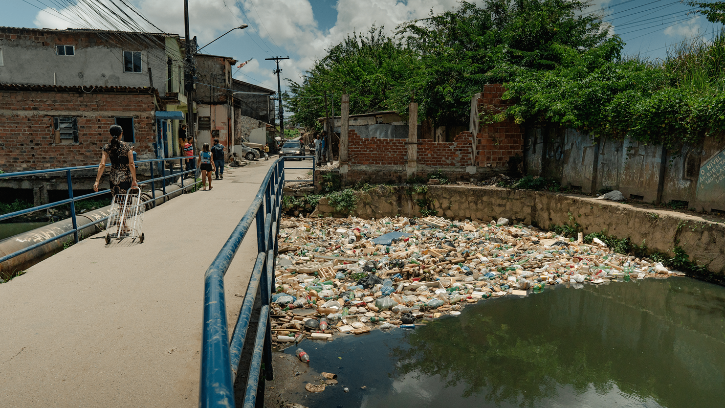 Plastic pollution blocks water in a river in Recife, Brazil, causnig regular flooding