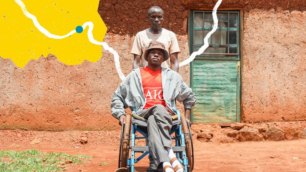 A man standing behind another man who is sitting in a wheelchair 