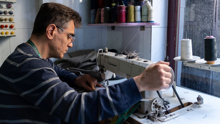 Photo of George working at his sewing machine