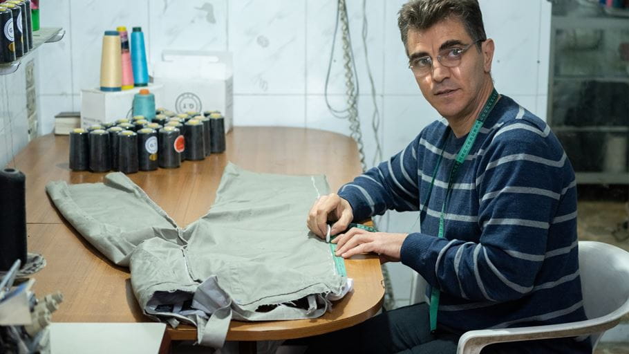 Photo of George tailoring a pair of trousers