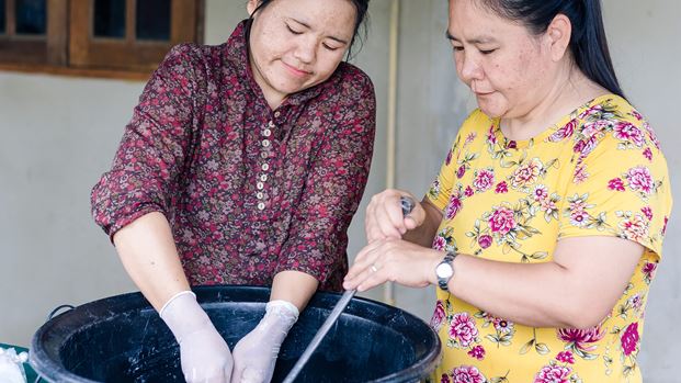Two women making washing up liquid