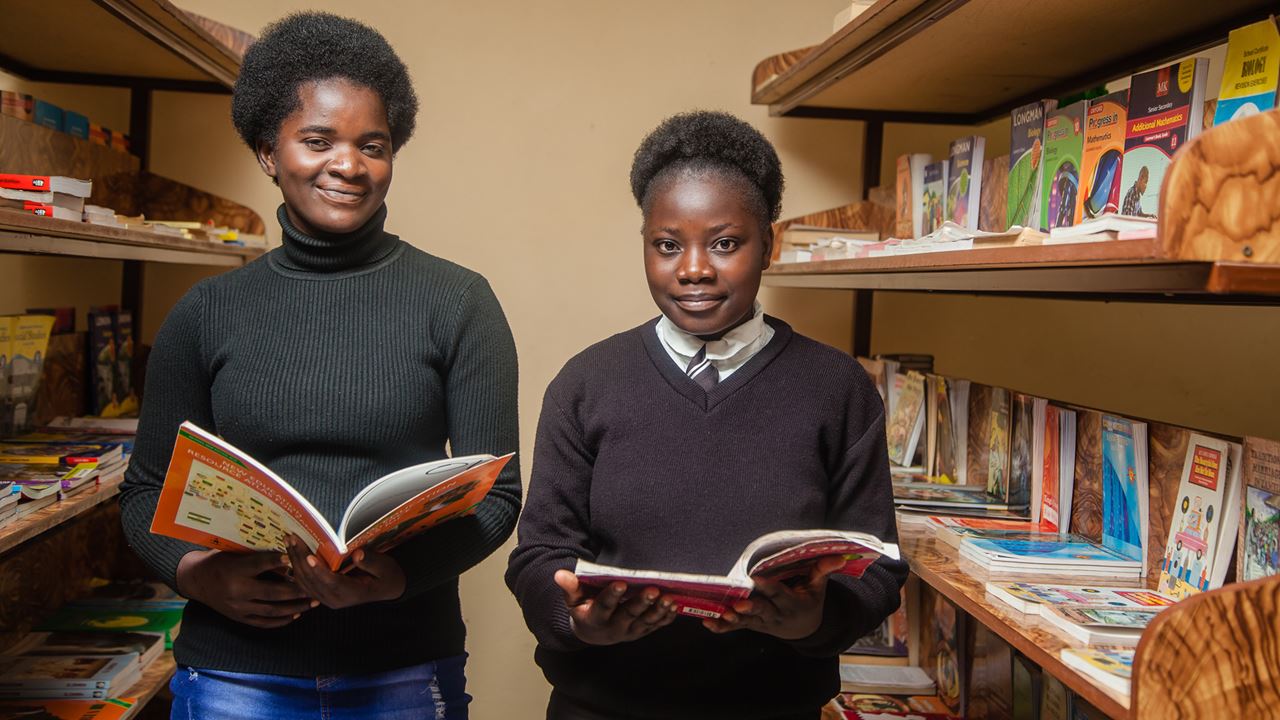 Two girls with books in the library