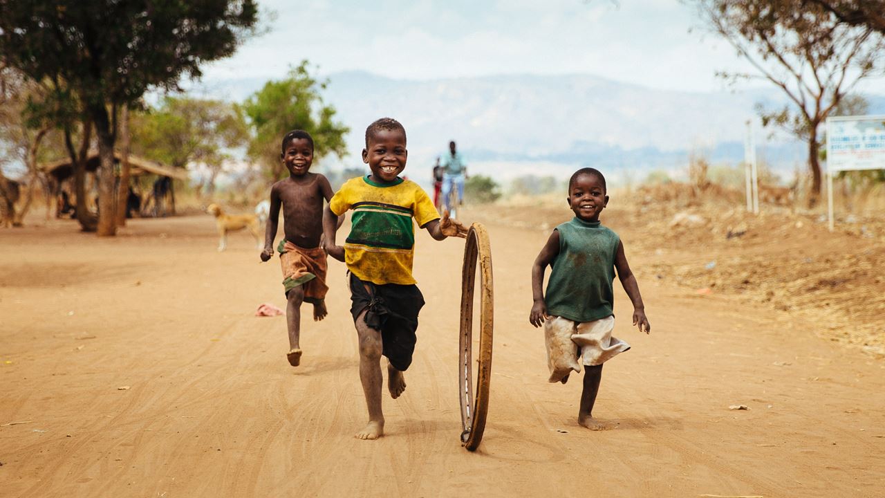 Group of children running happily down the road together