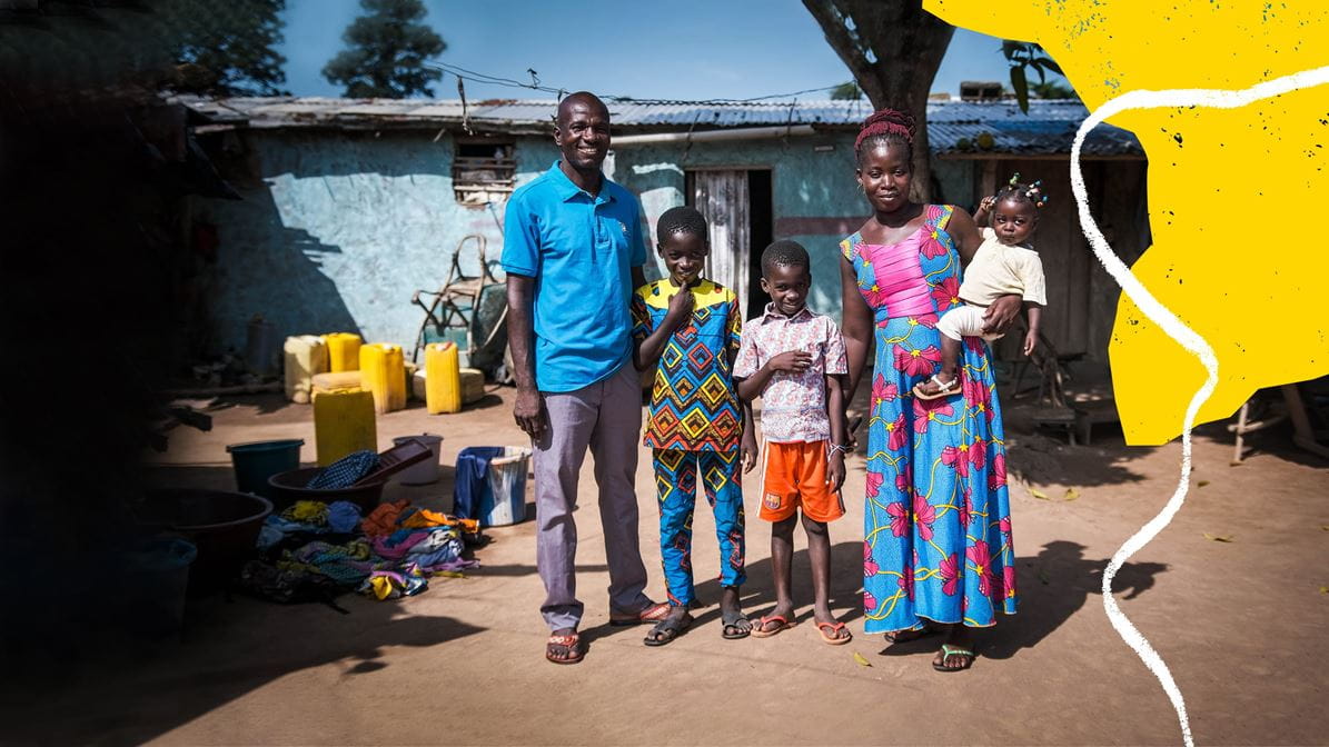 A family stand in front of a building.