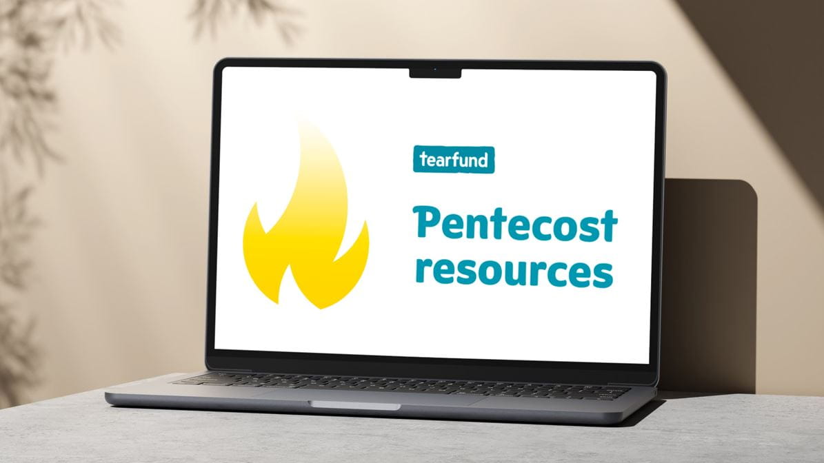 A laptop screen displaying the words 'Pentecost resources' and a graphic of a yellow flame.