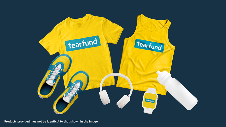 On a dark blue background, a graphic image of various Tearfund resources are spread out, including a Tearfund yellow t-shirt and running vest in the center.