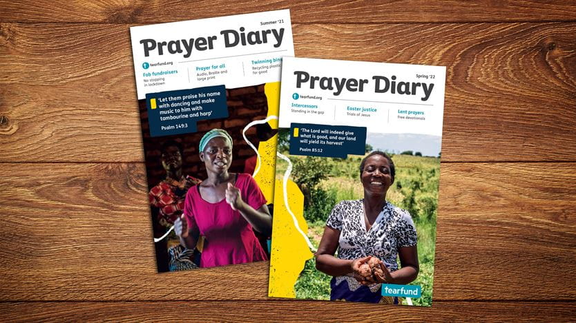 An image of two copies of the Prayer Diary on a wooden surface.