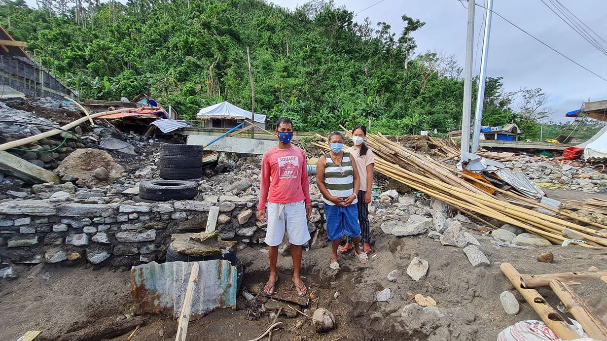 Rowena and her family stand outside their house destroyed by Typhoon Goni