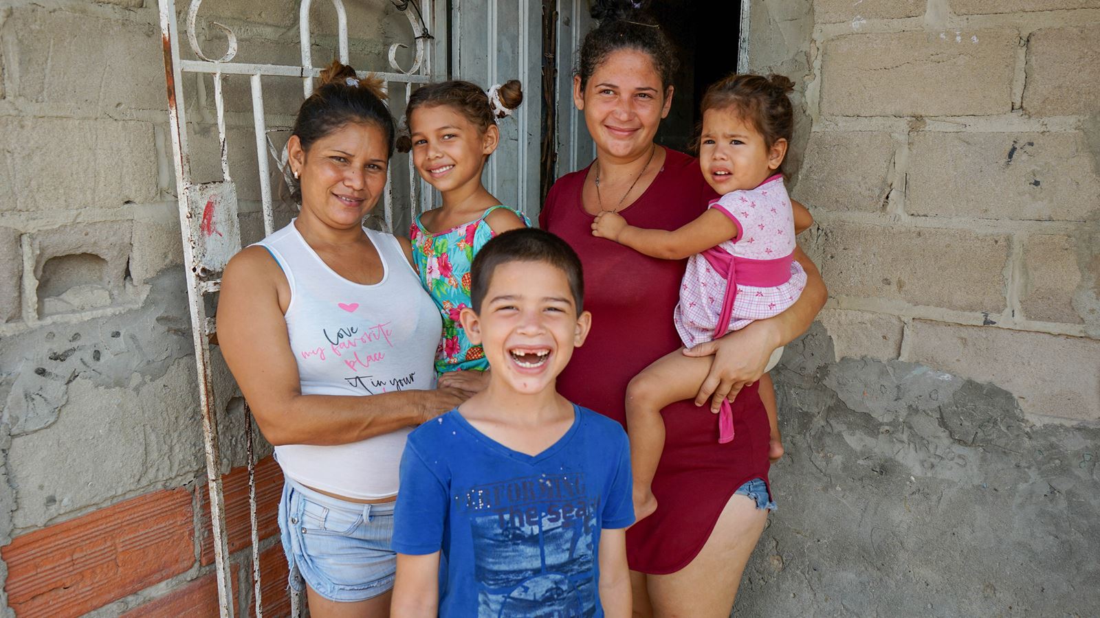 Smiling family outside home in Colombia