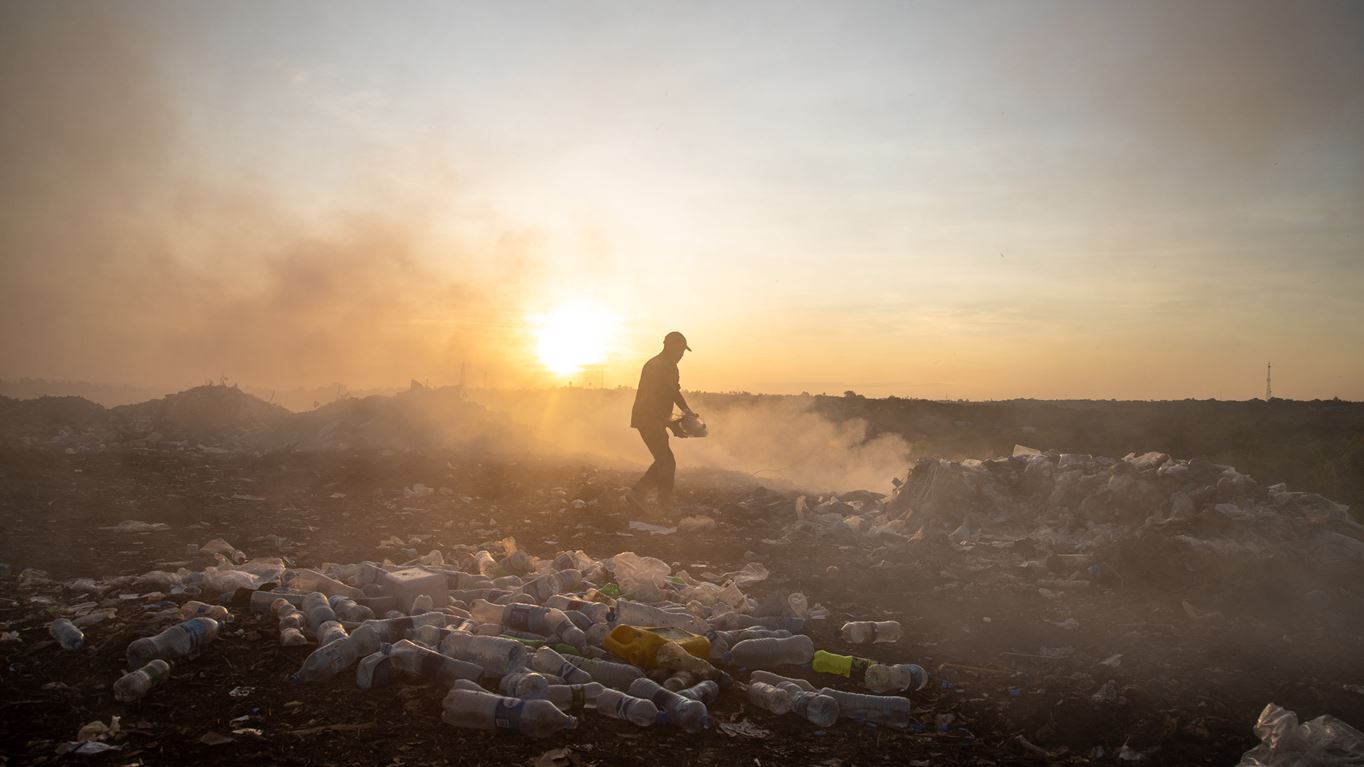November 15, 2019 - University of Dar es Salaam, Dar es Salaam, Tanzania - A waste picker collecting plastic bottles at the university dump at twilight. Daniel Msirikale/Tearfund