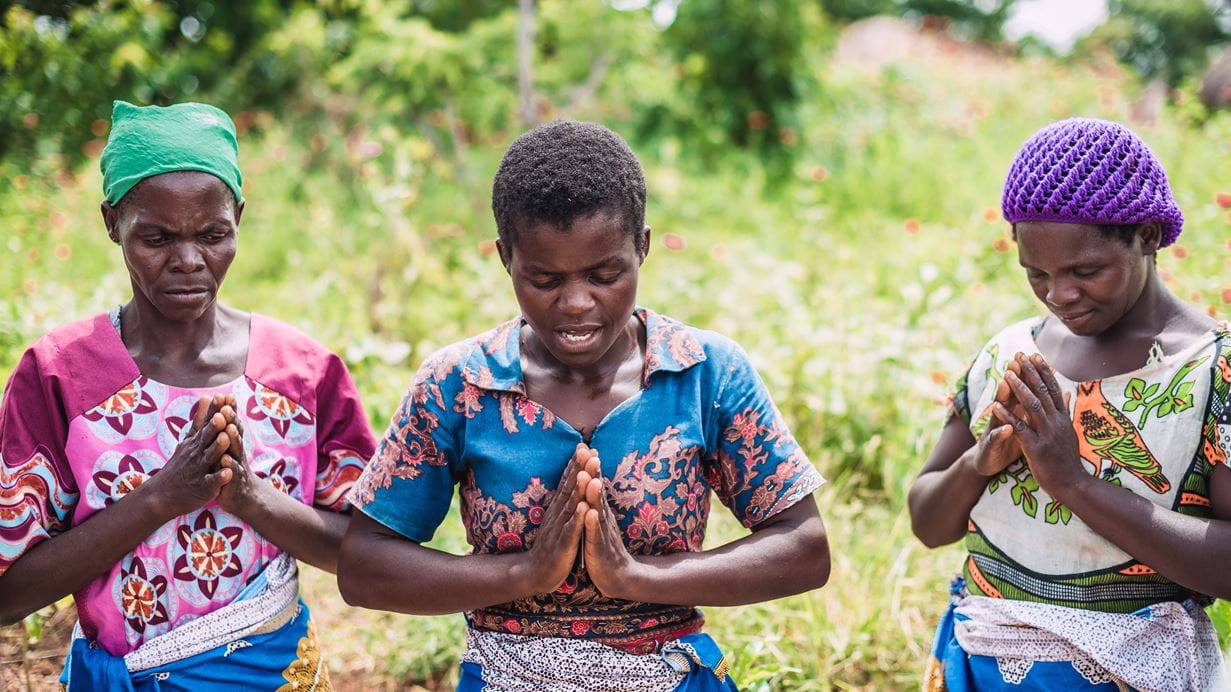 Prayer is powerful. Incredible things can happen when we join in with what God is already doing in the world. A self-help group, set up by Tearfund’s local partner in Malawi to help people overcome poverty together, gathers for prayer and singing. | Image credit: Alex Baker/Tearfund