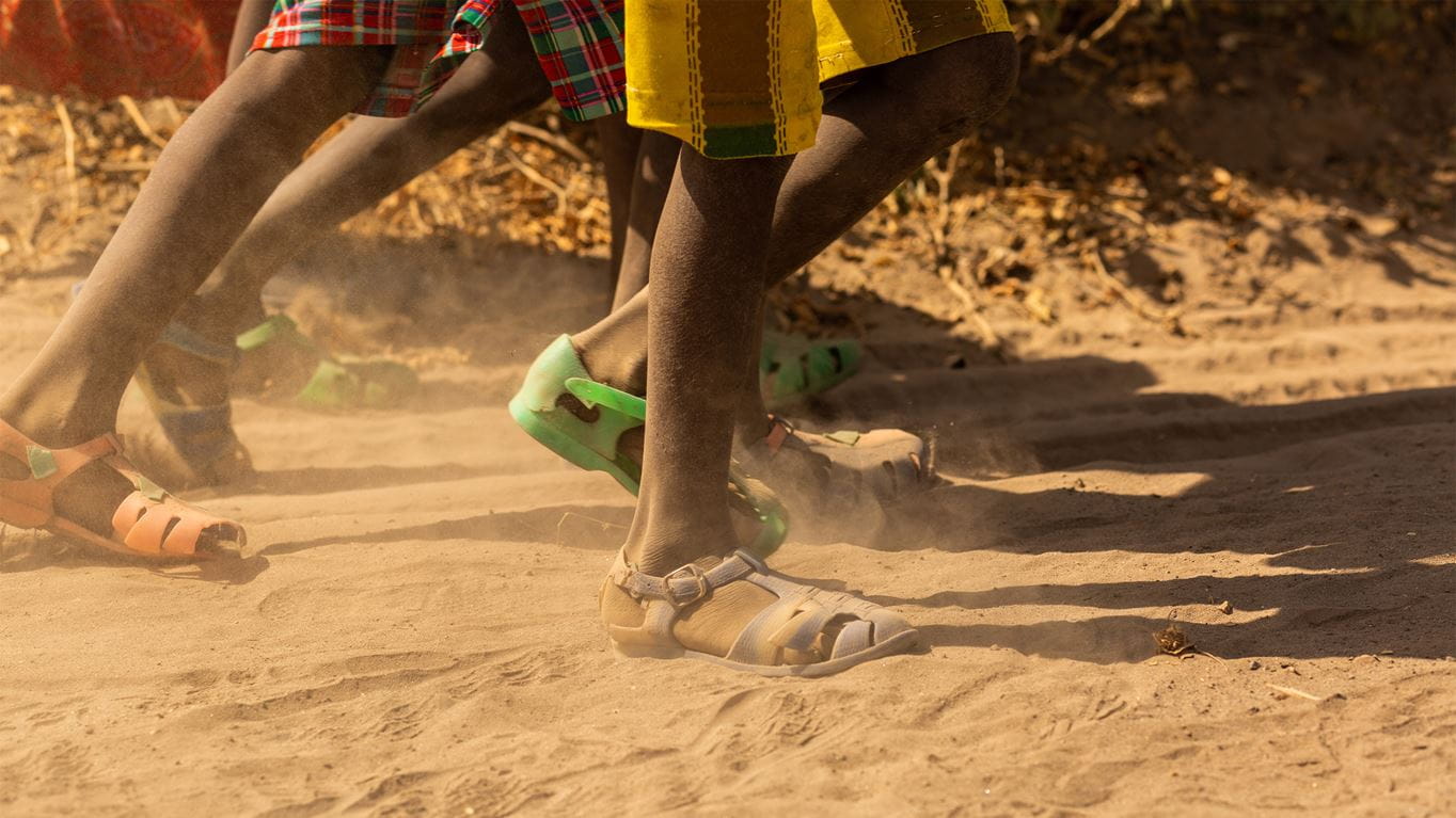 Feet running on sand. Image Credit: Chris Hoskins/ Tearfund