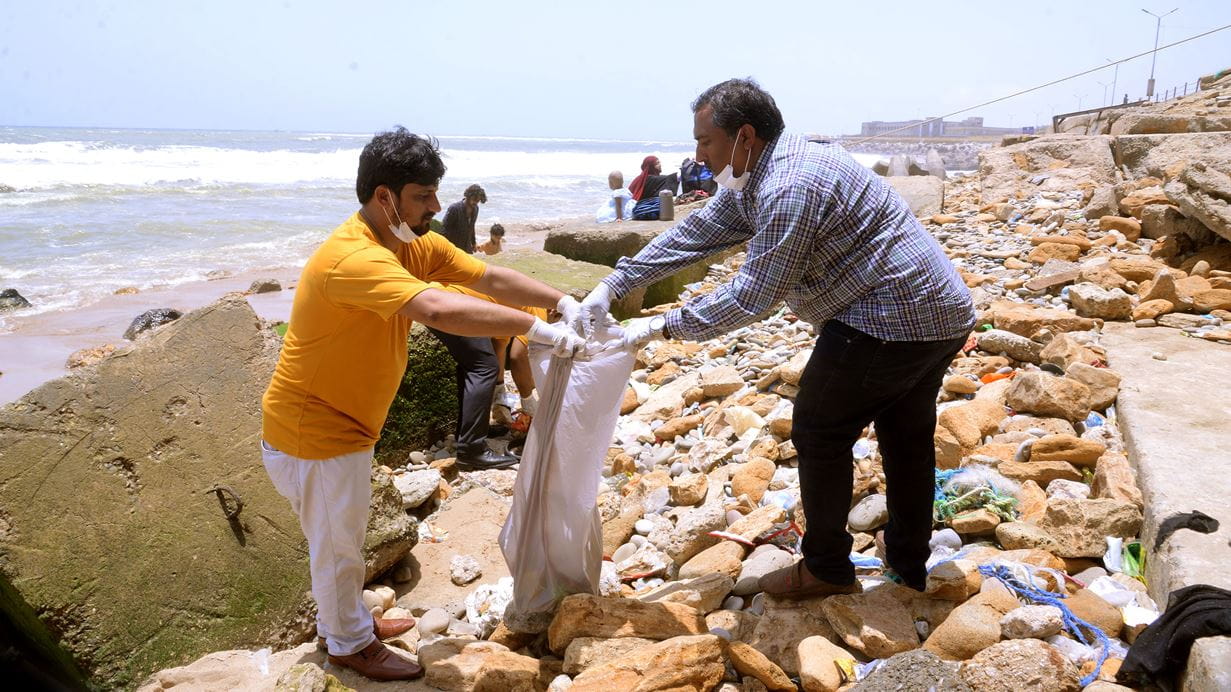 People collecting plastic waster and litter on a beach
