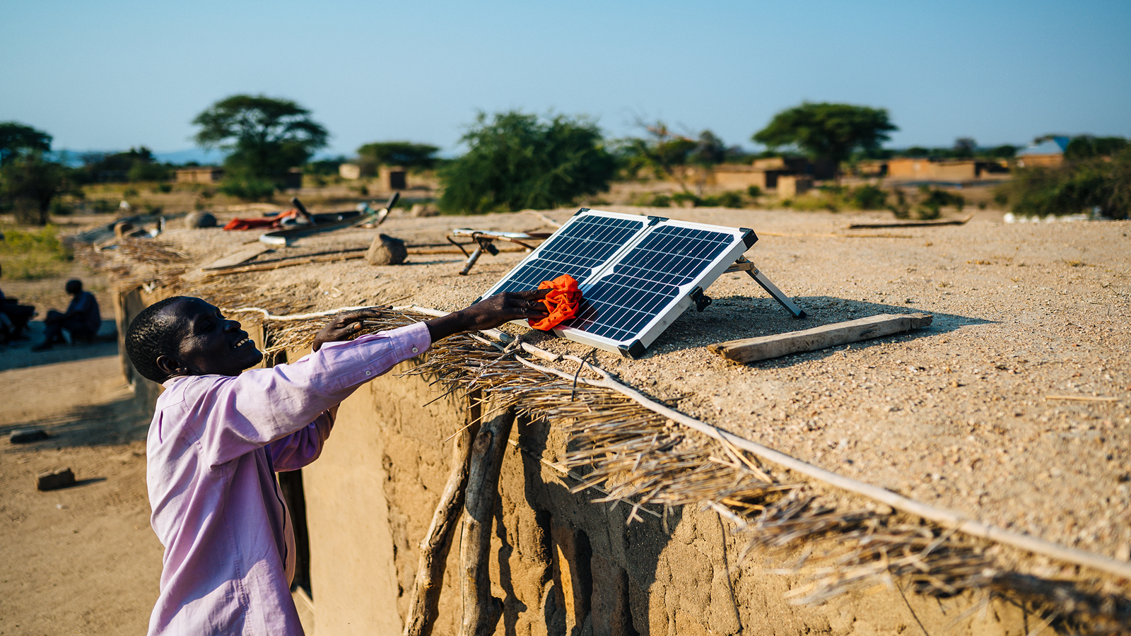 Lameck Chibago (59) proudly cleans, maintains and positions the solar panel on the roof of his house.