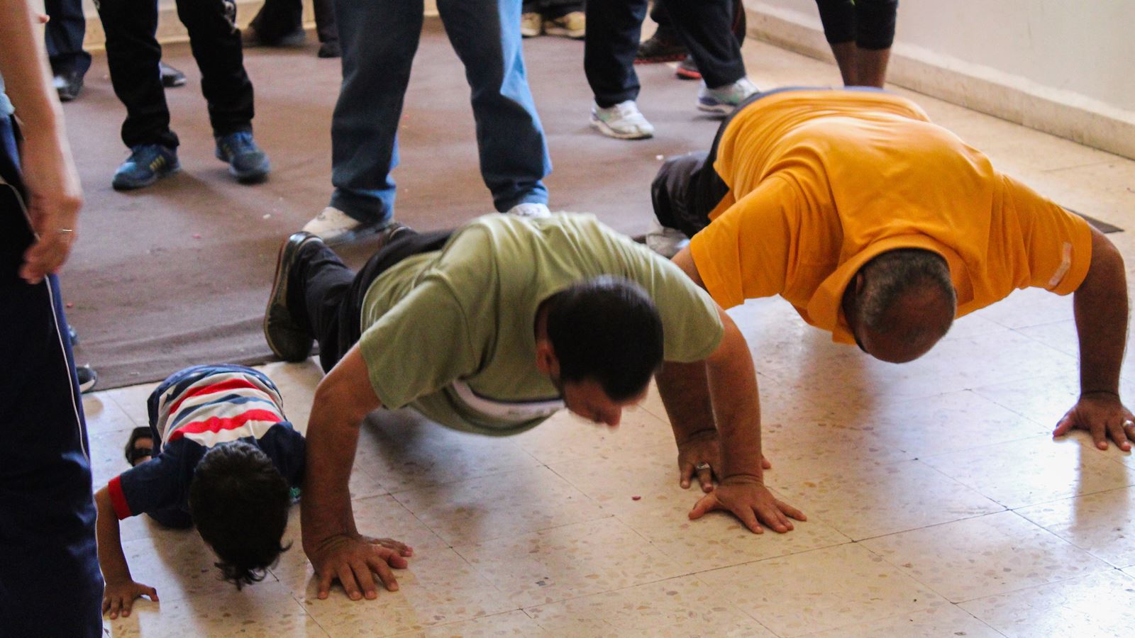 Two men and a boy doing push ups