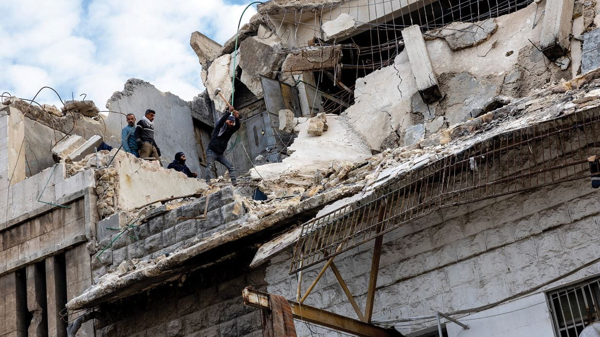  Four men clear debris from a collapsed apartment in a block in Aleppo, Syria.