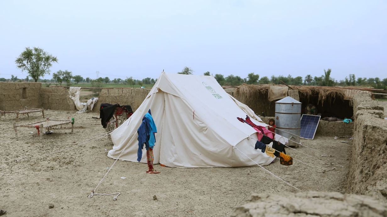 White tent with clothes hanging on the guide ropes