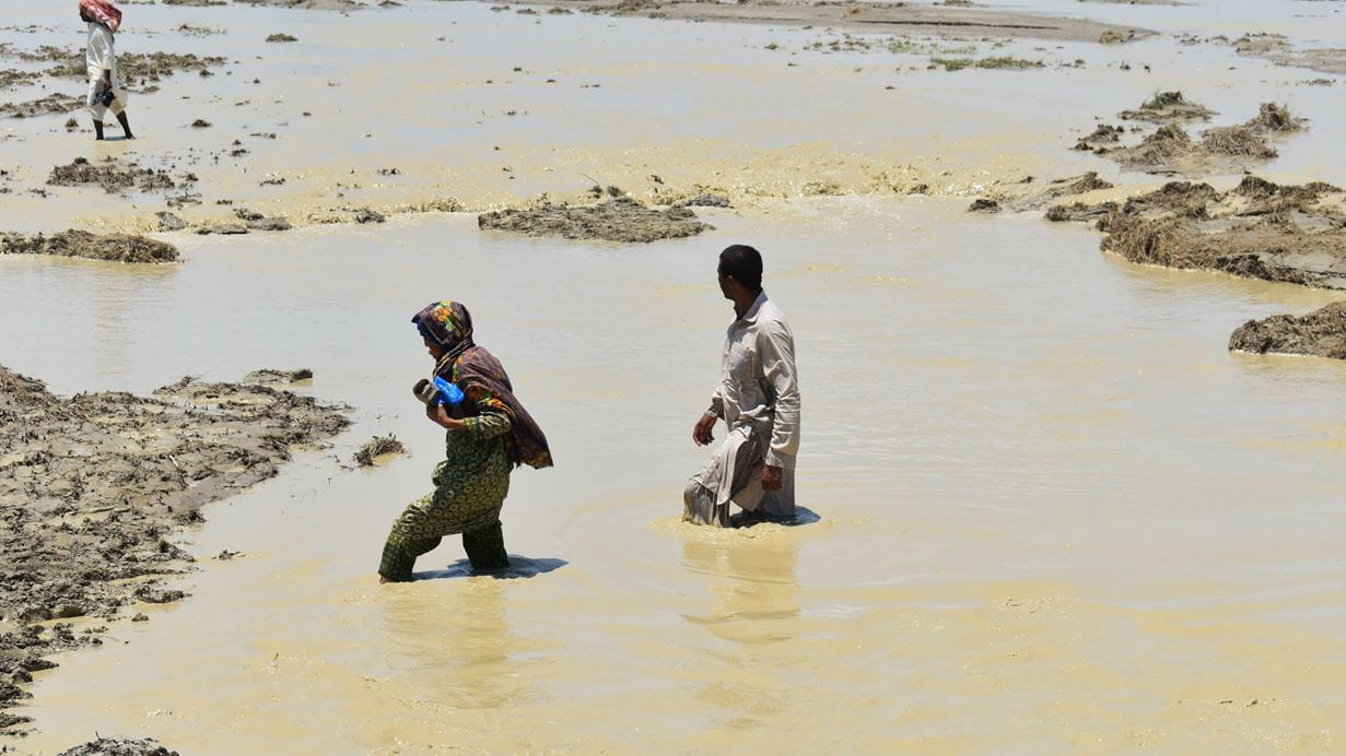 Two people walking through flood waters