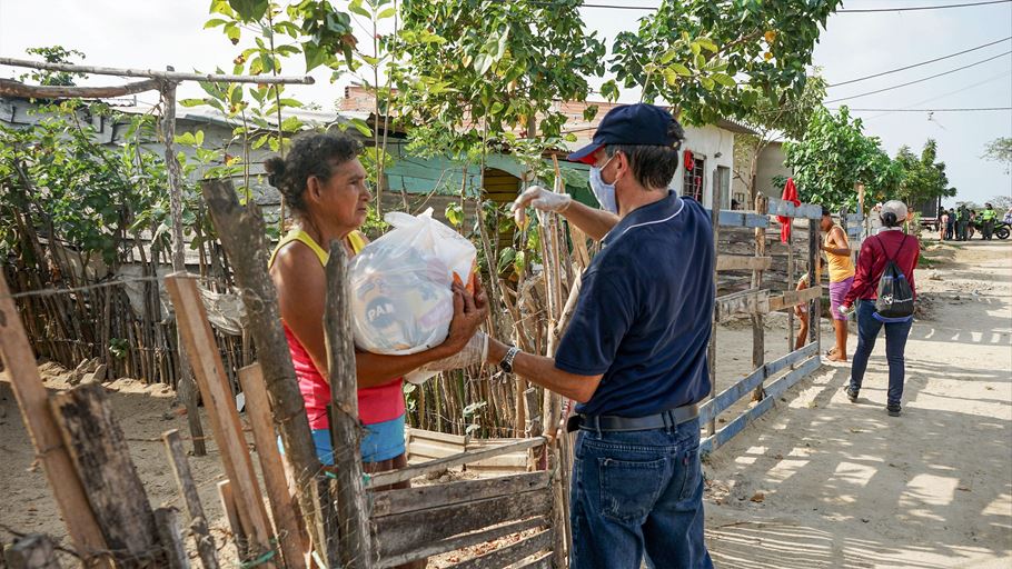 A man hands a food package to a woman.