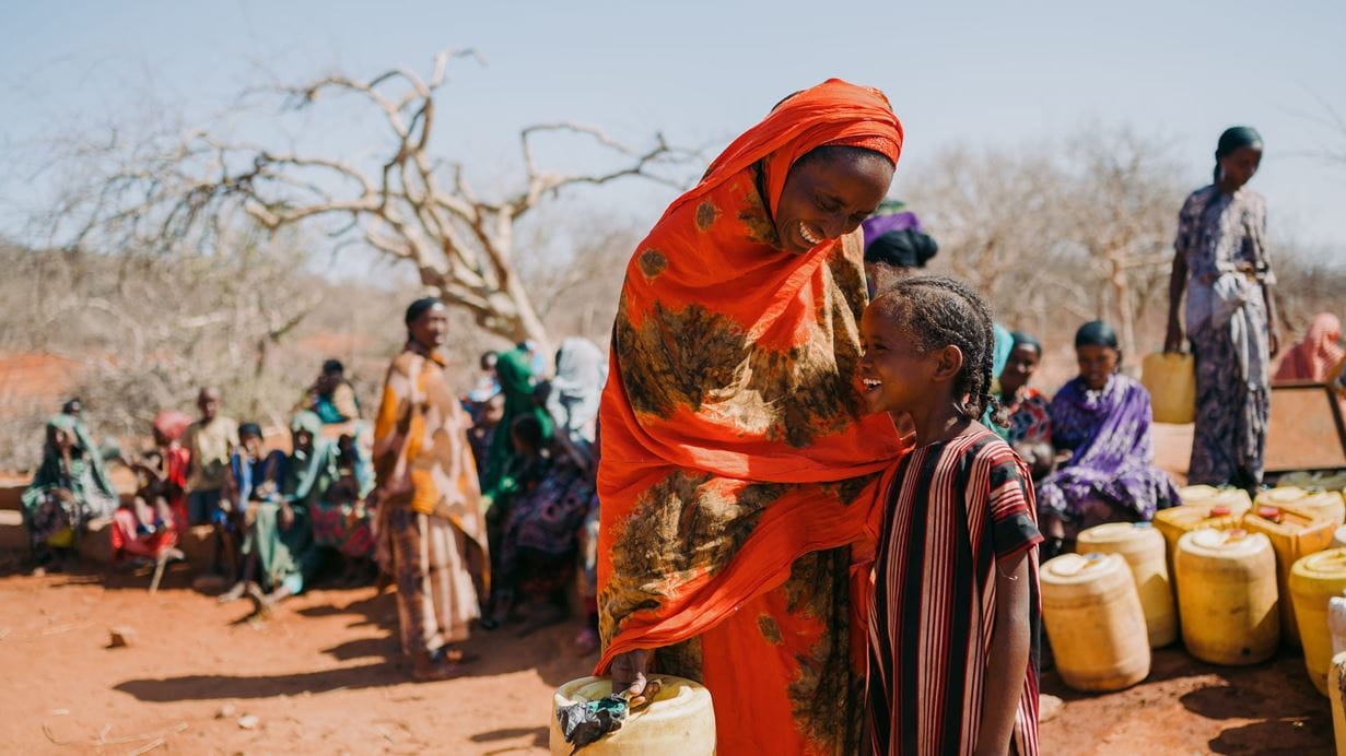 A mother and daughter stood beside each other laughing.